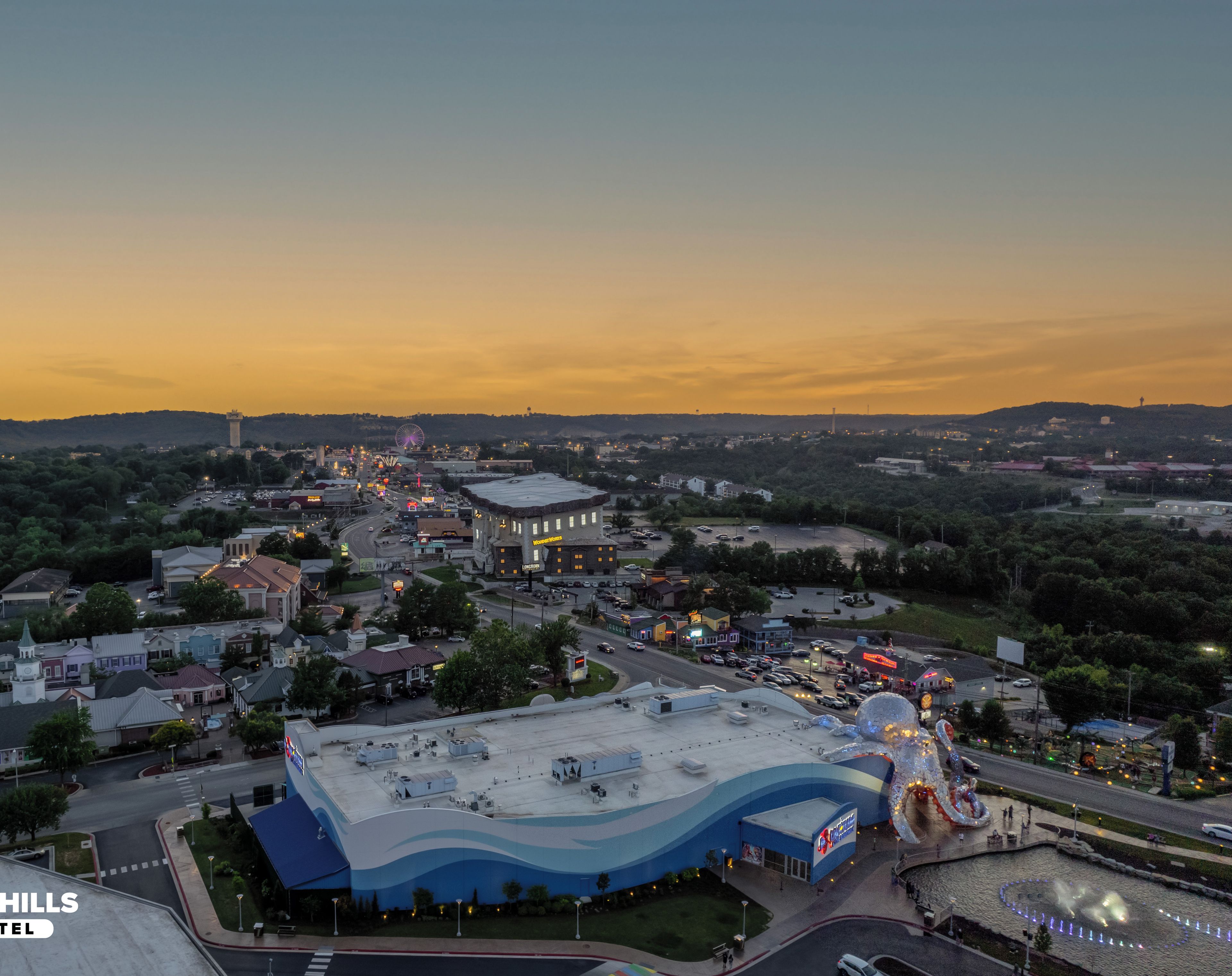 A resort hotel with a large building, a parking lot, and a view of the surrounding area.