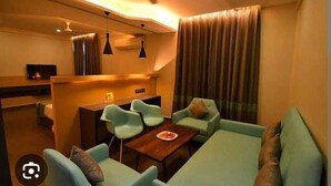Una sala de estar moderna con un conjunto de sofá, una mesa de centro y un comedor con una pequeña mesa y sillas.