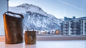 A view of a mountain through a window, with a metal bucket and a metal container on a windowsill. - In the center of town, close to the ski slopes, 3 rooms, 2 bedrooms for 4 people (Val-d'Isère)
