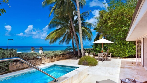 A pool area with a view of the ocean, palm trees, and outdoor furniture. - Enchanting Beachfront Retreat - Leamington Cottage 1 Bedroom Villa by Blue Sky Luxury (Speightstown)