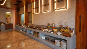 Una mesa de buffet con diferentes tipos de comida y una barra larga.