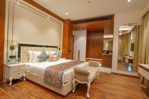 Un dormitorio amplio con una cama grande, una mesita de noche con lámpara y una silla.
