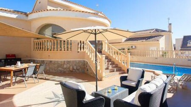 Zona junto a la piscina con mobiliario exterior, una escalera y vistas a la piscina.
