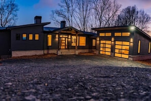 A two-story house with a garage, a covered porch, and a driveway.