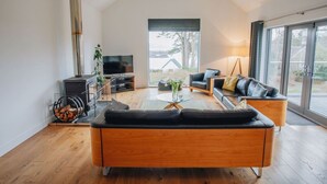 A modern living room with a sofa, TV, and fireplace. - Carnanamish a Luxurious Cottage in Tobermory (Tobermory)