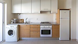 Una cocina equipada con lavadora, estufa, horno y refrigerador.