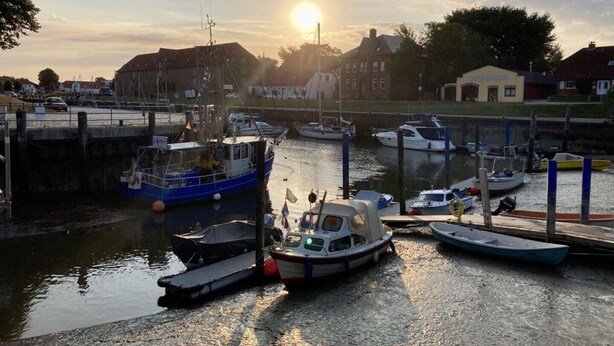 A marina with various boats docked, a lock system, and buildings in the background. - Vacation apartment "Norderhus" (WH2) with 70sqm - quiet central location - with balcony (Tönning)