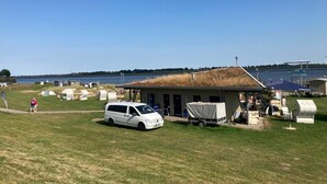 A campsite with a white van, portable toilets, and tents. - Vacation apartment "Norderhus" (WH2) with 70sqm - quiet central location - with balcony (Tönning)