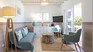A modern living room with a sofa, chairs, a coffee table, and a television. - Beach house, 2 steps from the ocean! (Faro)