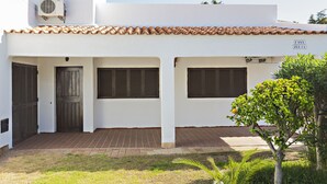 A white building with a tiled roof, a wooden door, and a sign reading "CASA ZELIA".