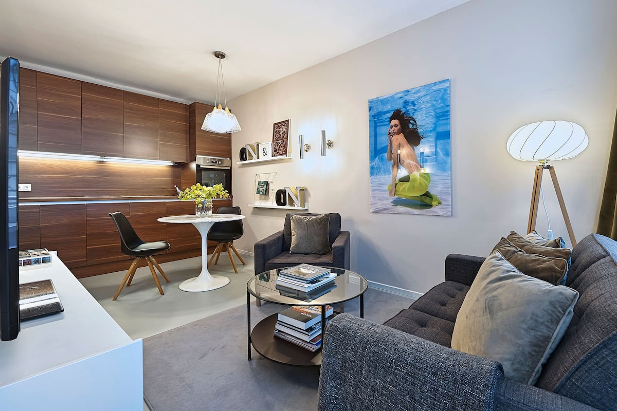 A modern living room with a sofa, coffee table, and a dining area with a small table and chairs.