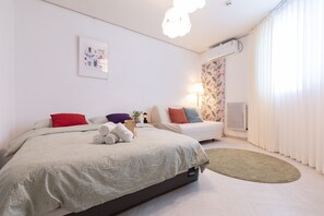 A modern hotel room with a large bed, a sofa, a small table, and a window with curtains. - dodo stay (Chuncheon)