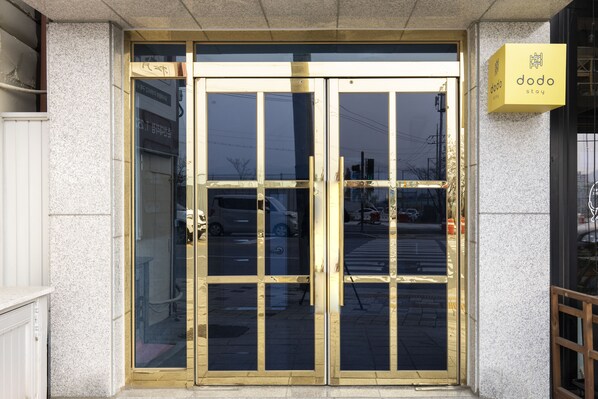 A hotel entrance with a glass door and a sign reading "dodo stay". - dodo stay (Chuncheon)