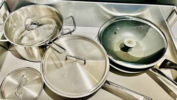 A kitchen area with stainless steel cookware, including pots and pans.