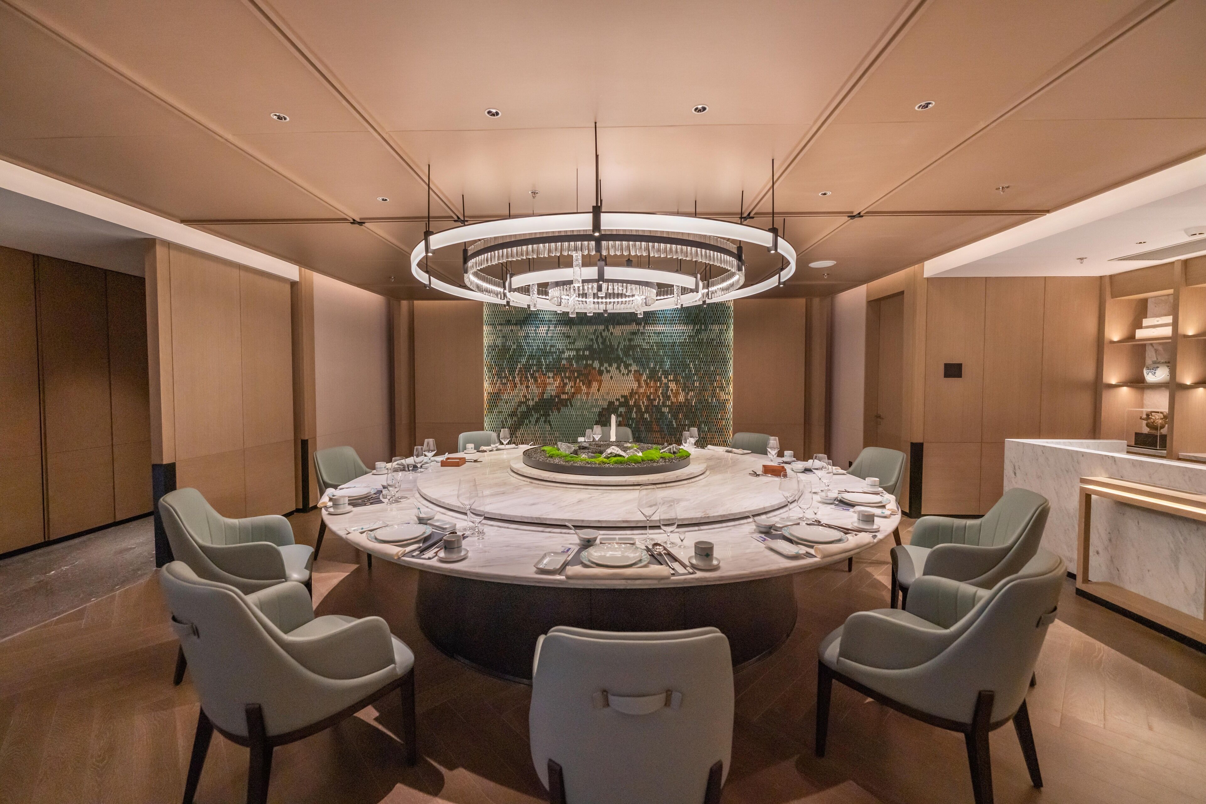 A modern dining area with a round table, six chairs, and a central decorative piece.