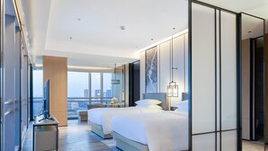 A modern hotel room with a large bed, a desk, and a city view. - Changzhou Marriott Hotel Jintan (Changzhou)