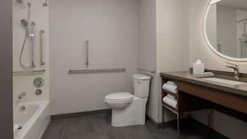 A modern bathroom with a bathtub, toilet, shower, and sink.