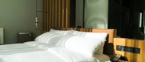 Una habitación de hotel con una cama grande, una mesita de noche con un teléfono y un espejo.