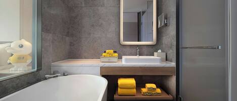 A modern bathroom with a bathtub, a sink, and a mirror.