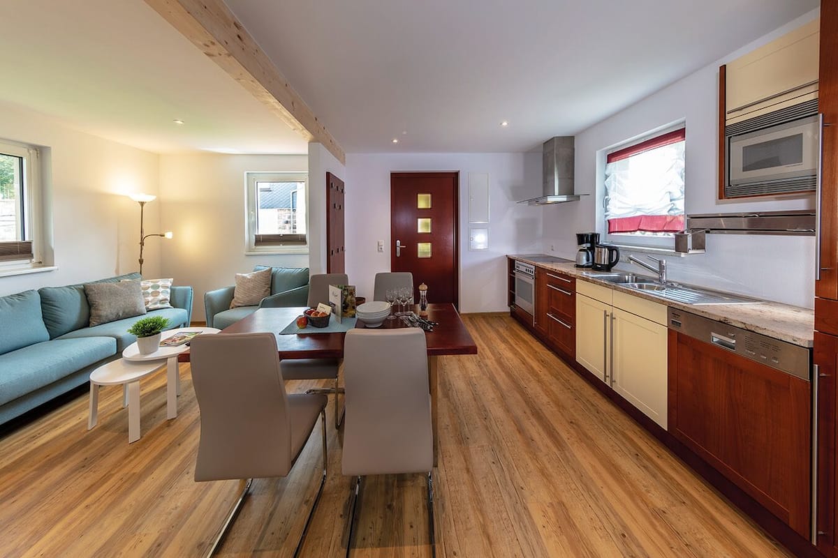 Un appartement moderne comprenant un salon, un coin repas et une cuisine.