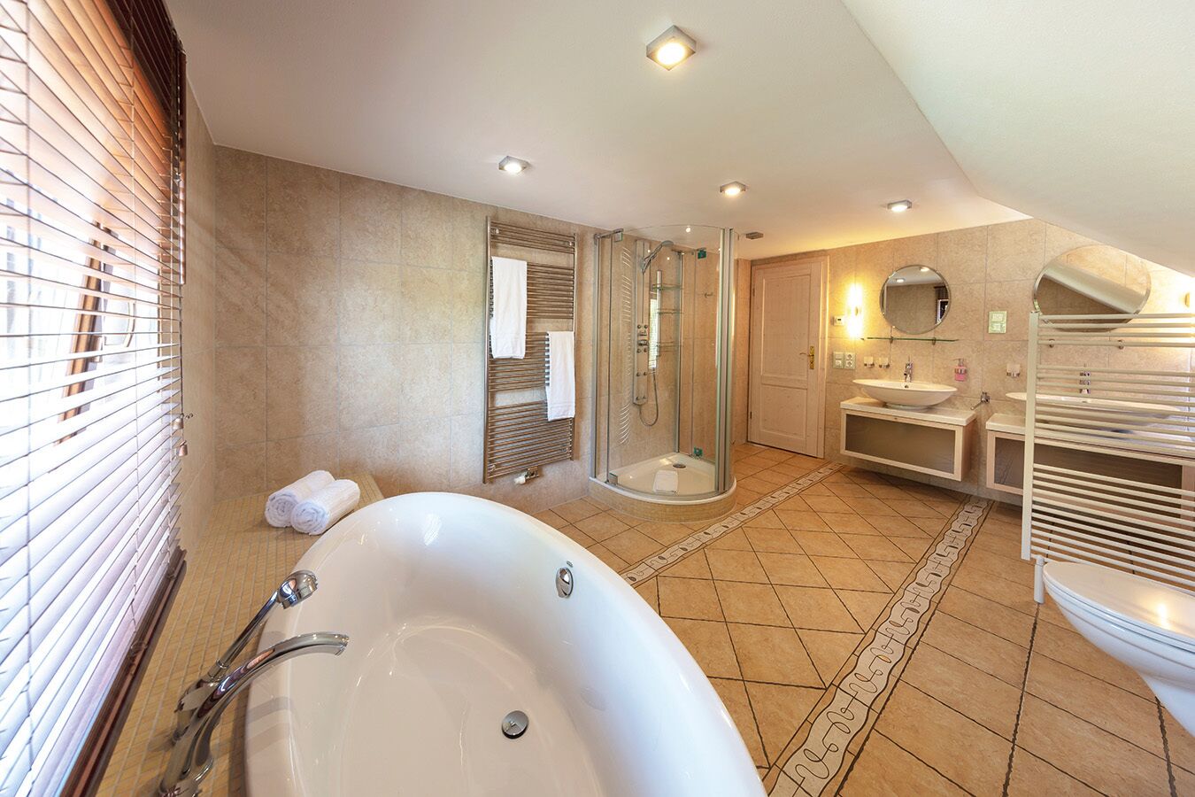 A modern bathroom with a freestanding bathtub, a glass-enclosed shower, and a vanity with a sink and mirror.
