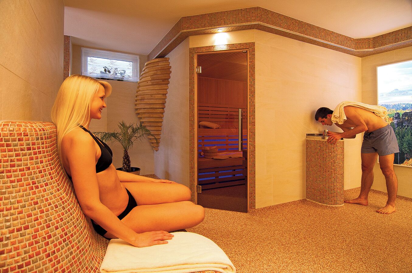 Un cuarto de spa con una camilla de masaje, una planta pequeña y un rincón de ducha.