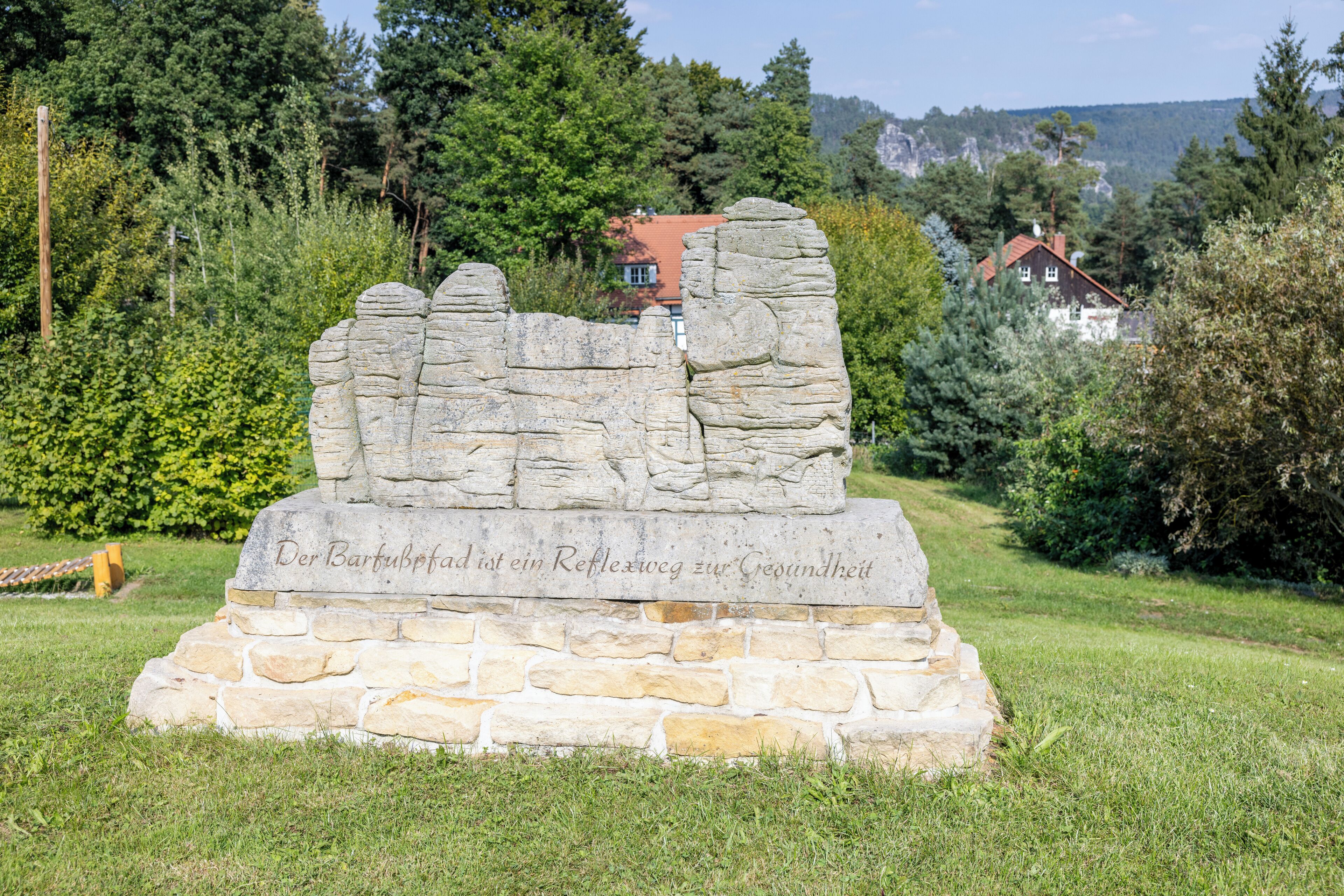 A stone monument with inscriptions in a natural setting.