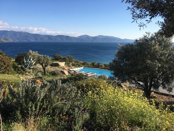 A pool area with a view of the sea and mountains.