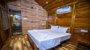 Una habitación de madera con una cama, un espejo y un equipo de aire acondicionado.