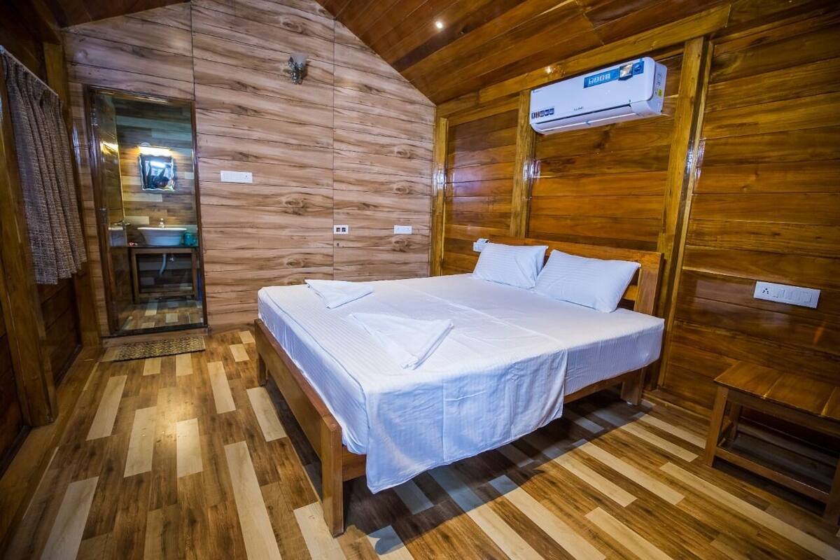 A wooden room with a bed, a mirror, and an air conditioning unit.