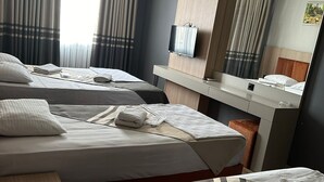A hotel room with two beds, a flat-screen TV, a mirror, and a desk. - Metros Hotel (Mersin)