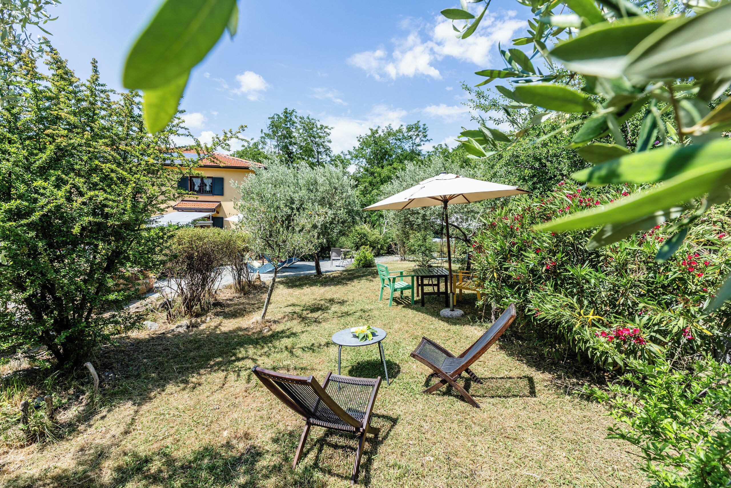A garden patio with a table, chairs, and an umbrella.