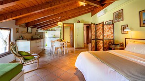 Amplia habitación con techos altos, una cama, comedor y cocina.