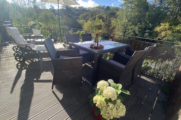 Große Terrasse mit zwei Sonnenschirmen, Essplatz, Liegen und Aussicht in Garten