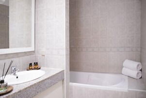 Un bagno con lavandino, specchio e vasca da bagno.