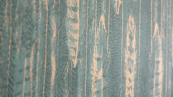 A close-up of a textured surface with vertical lines and a worn appearance.