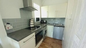 A compact kitchen with a stove, oven, microwave, and sink. - Angel Lane Apartment. Alnwick Town Centre (Alnwick)