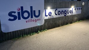 Une enseigne indiquant « Siblu Villages », avec l’inscription « Le Conguel » sur une clôture en bois.