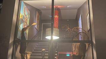 Een modern interieur met een trap, een groot raam en abstracte kunst.
