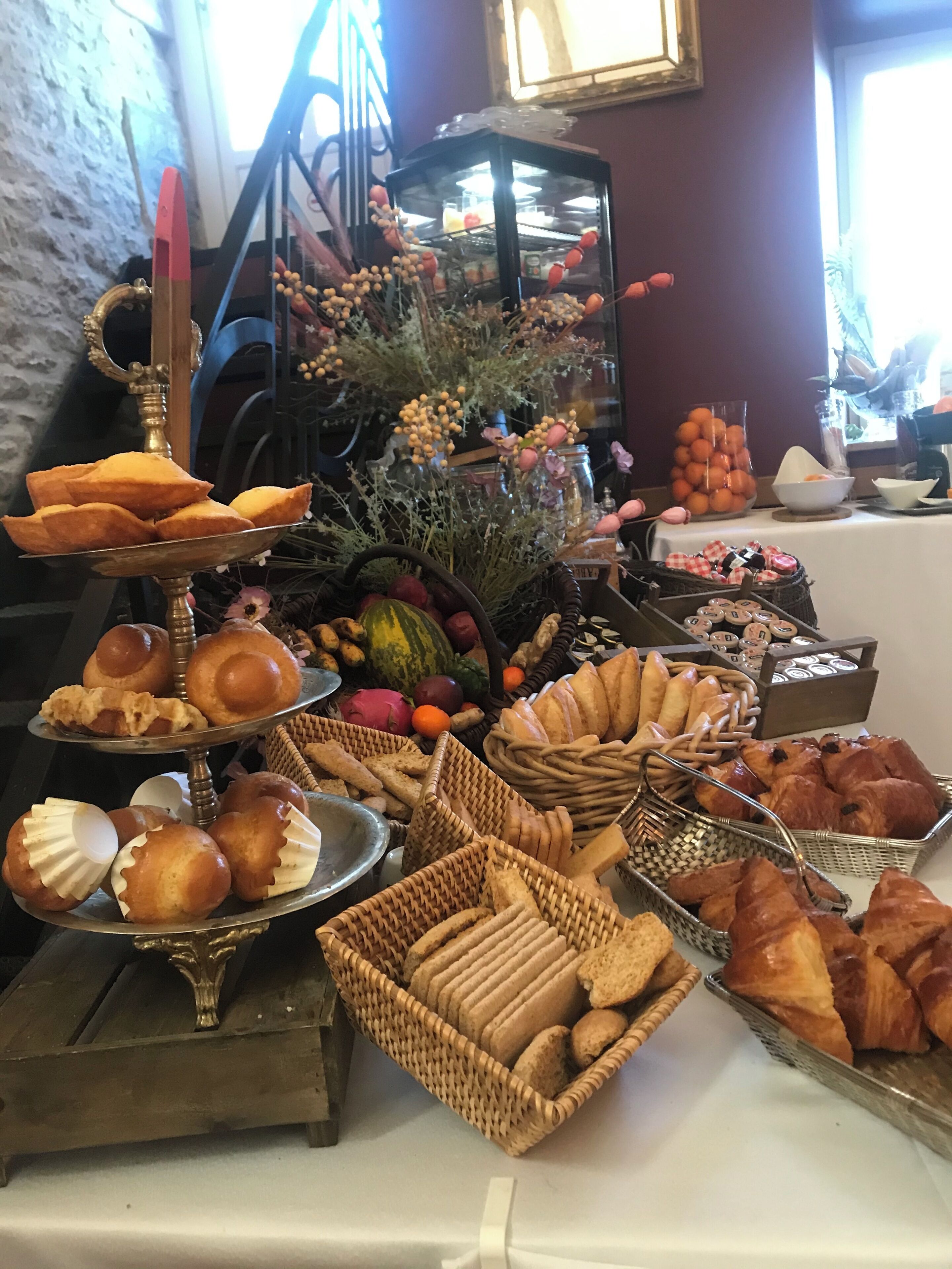Una mesa de buffet con diversos productos horneados y frutas y verduras frescas.
