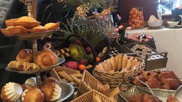 Una mesa de buffet con diversos productos horneados y frutas y verduras frescas.