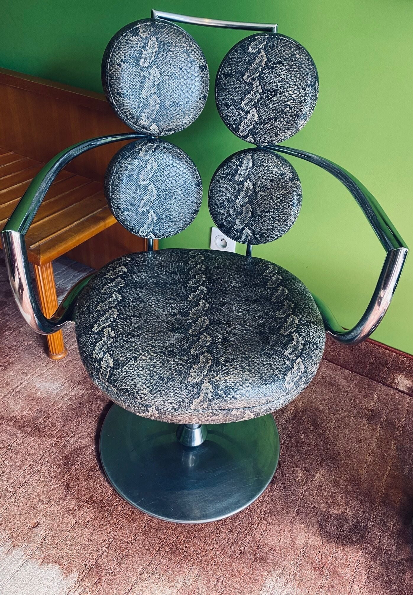A chair with a unique design featuring multiple spherical elements on the backrest.