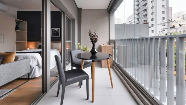 A modern apartment with a balcony, a dining area, and a bedroom. - Charlie Edição Jardim Paulista (São Paulo)