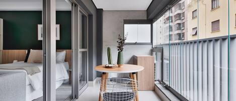 Een moderne slaapkamer met een bed, nachtkastje en raam.