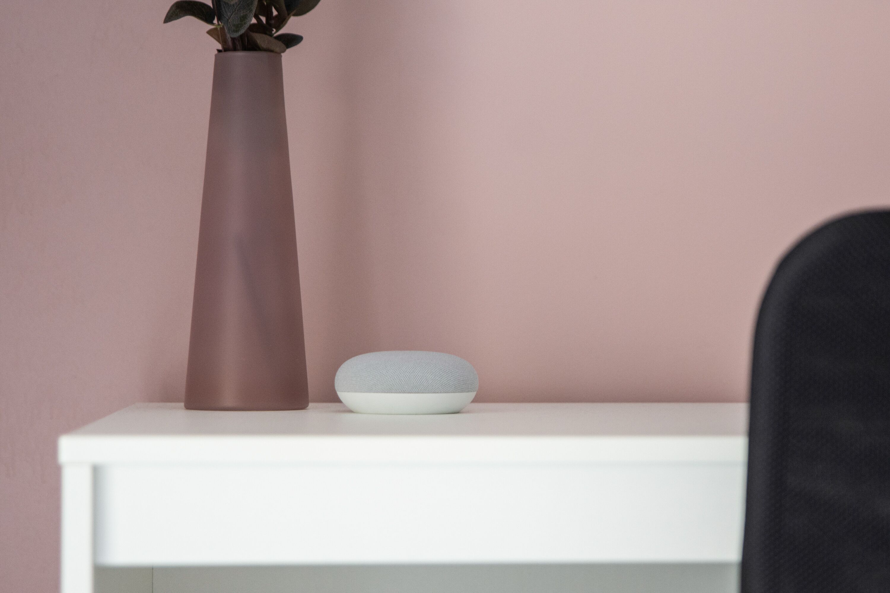 Une étagère blanche sur laquelle se trouvent un grand vase marron et un petit objet gris.