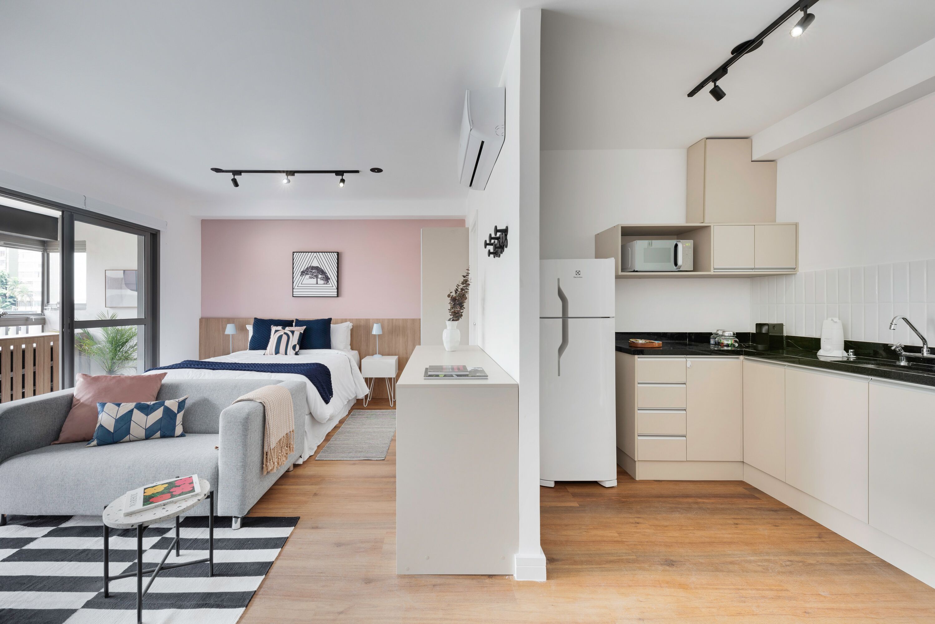 Un apartamento moderno con sala de estar, kitchenette y un dormitorio.