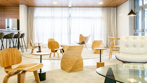 A modern interior with wooden flooring, a glass coffee table, and contemporary furniture. - Charlie Edição Jardim Paulista (São Paulo)