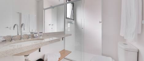 A modern bathroom with a glass-enclosed shower, a large mirror, and a wooden vanity.