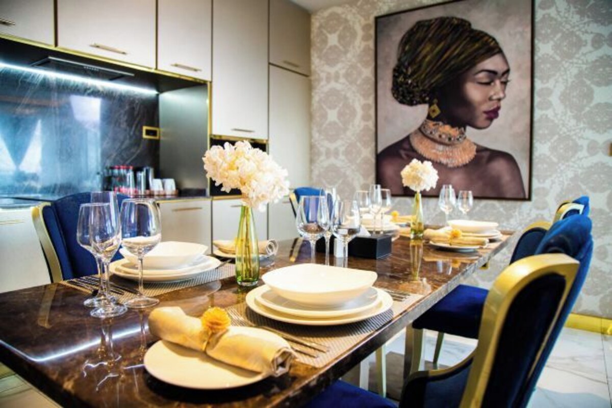A dining table set with plates, glasses, and a vase of flowers.