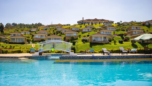 A residential area with a swimming pool, houses, and a bridge.